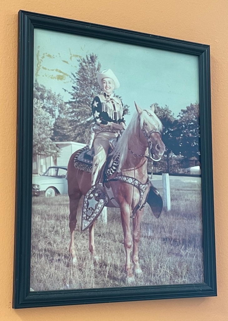 Photograph of Sally Starr on a Palomino Horse with Western tack Hanging at Sally Starr's Pizza restaurant