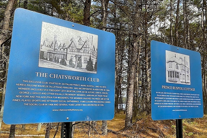 Two blue historical markers in front of the the woods of Chatsworth Lake marking the site of the Chatsworth Club with pictures and description of historic buildings, ; beachandbarrens.com watermark
